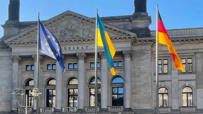 Ukrainische Flagge zusammen mit der EU- und Deutschlandflagge vor dem Bundesrat